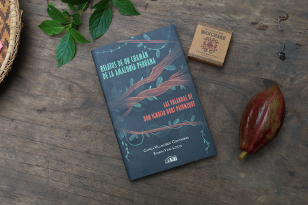 Book titled 'Las Palabras de Don Ignacio Duri Palomeque' on a wooden surface with a box of incense, leaves, and a fruit